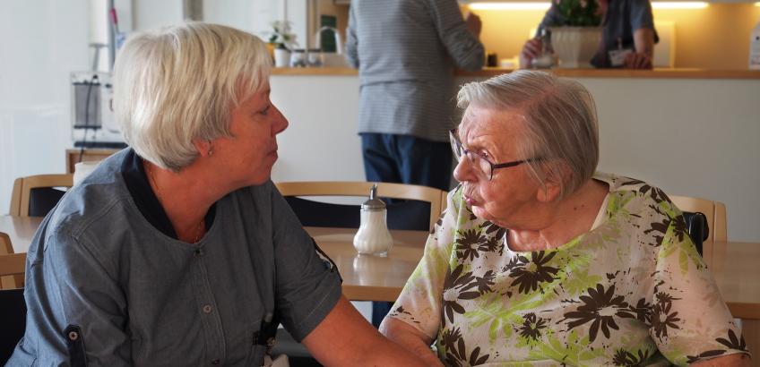Ansat på Plejecenter Kirstinehaven taler med beboer